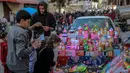 Anak-anak Palestina melihat mainan yang dipajang oleh seorang pedagang kaki lima di Kota Gaza pada 8 Maret 2024. (Foto: AFP)