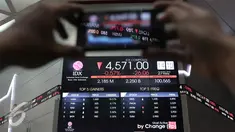 Pengunjung memfoto pergerakan Indeks Harga Saham Gabungan di Bursa Efek Indonesia, Jakarta,  Jumat (27/11). Bursa saham Indonesia kembali melemah pada penutupan perdagangan hari ini. (Liputan6.com/Angga Yuniar)