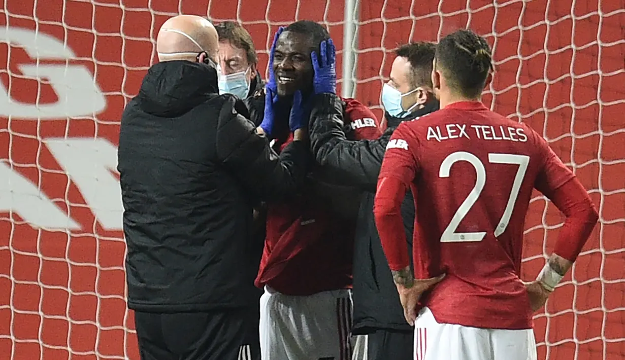 Bek Manchester United, Eric Bailly (tengah) mendapat penanganan tim medis usai terlibat benturan dengan pemain Watford dalam laga babak ke-3 Piala FA 2020/21 di Old Trafford, Sabtu (9/1/2021). Manchester United menang 1-0 atas Watford. (AFP/Oli Scarff/Pool)