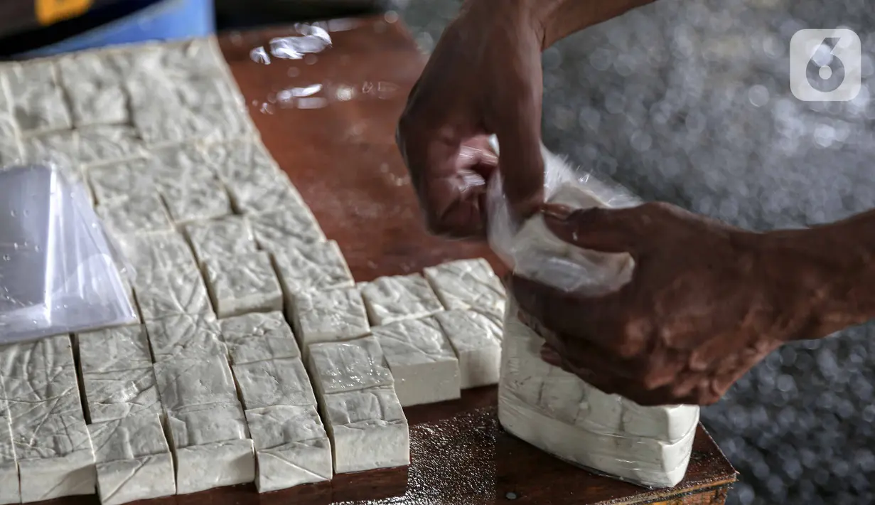 Pekerja memproduksi tahu di kawasan Duren Tiga Raya, Jakarta, Kamis (24/2/2022). Produsen tahu tempe kembali berproduksi usai aksi mogok selama tiga hari karena harga kedelai yang naik hingga menyentuh Rp12.000 dari semula Rp9.500 per kg dalam beberapa bulan terakhir. (Liputan6.com/Faizal Fanani)