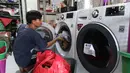 Pekerja tengah mencuci pakaian di toko laundry di Jakarta, Rabu (20/6). Libur lebaran banyak jasa laundry kebanjiran order hingga 100 karena banyaknya para pembatu rumah tangga yang mudik lebaran. (Liputan6.com/Angga Yuniar)