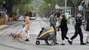 Orang-orang berjalan-jalan dengan anjing mereka di Melbourne, Australia, Kamis (30/9/2021). Melbourne bergulat dengan lonjakan infeksi Covid-19 di mana sebanyak 1.438 kasus dilaporkan, jumlah harian terbesar sejak awal pandemi. (William WEST / AFP)