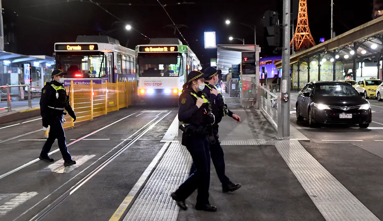 Petugas penegak hukum berpatroli di jalan-jalan selama aturan jam malam di Melbourne, pada Selasa (17/8/2021). Kota terbesar kedua di Australia itu memberlakukan pembatasan tinggal di rumah pada pukul 9 malam hingga 5 pagi untuK meredam lonjakan Covid-19 varian Delta. (William WEST/AFP)