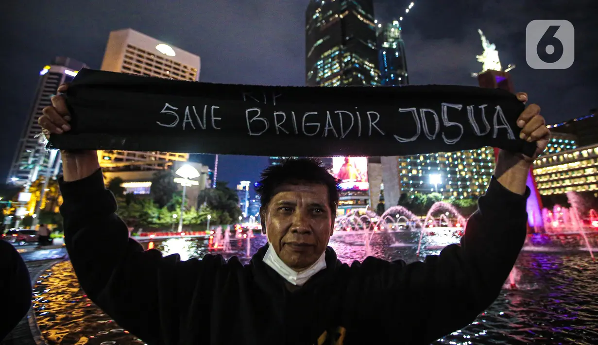 Massa aksi yang tergabung dalam Tim Advokat Penegak Hukum dan Keadilan (Tampak) membentangkan kain hitam saat aksi 1000 lilin atas kematian Brigadir Yosua Hutabarat atau Brigadir J di Bundaran HI, Jakarta, Jumat (22/7/2022). Aksi tersebut sebagai bentuk keadilan terkait kematian Brigadir J yang diduga akibat penyiksaan. (Liputan6.com/Faizal Fanani)