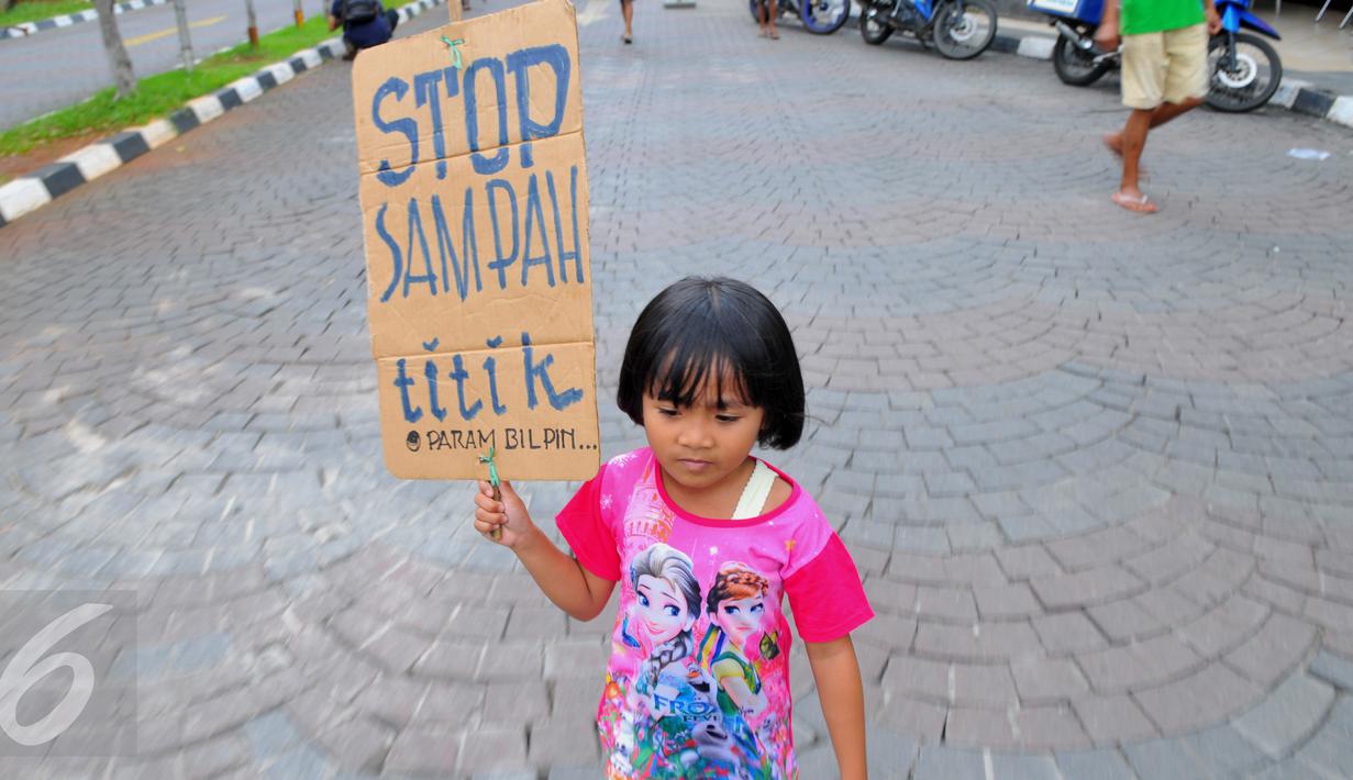 Anak - anak membawa papan bertuliskan " Stop Sampah Titik" saat melakukan aksi bersih - bersih sampah di Jakarta, (21/2). Anak-anak dan masyarakat luas bersama-bersama untuk memungut sampah. (Liputan6.com/Faisal R Syam)
