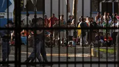 Sekelompok narapidana terlihat di sebuah penjara dengan keamanan maksimum di Guatemala, Senin (30/11). 16 tahanan tewas dalam perkelahian antarnapi di penjara tersebut. Sementara keluarga menunggu dengan cemas di luar penjara. (AFP Photo/JOHAN ORDONEZ)