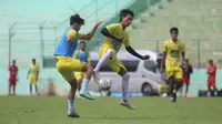 Kapten Arema, Ahmad Alfarizi berduel dengan pemain dari Akademi Arema dalam latihan di Stadion Gajayana Malang, Rabu (16/11/2022). (Bola.com/Iwan Setiawan)