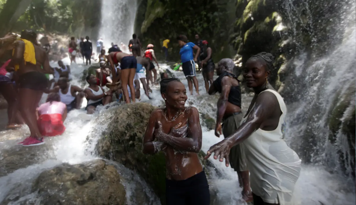 Sejumlah  peziarah mandi di bawah air terjun di Saut d' Eau, Haiti, (16/7). Ini merupakan ritual tahunan untuk menyembuhkan penyakit dan mensucikan diri. (REUTERS/Andres Martinez Casares)