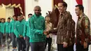 Presiden Jokowi bersalaman dengan Boaz Solossa saat menyambut kedatangan timnas Indonesia ke Istana Merdeka, Jakarta, Senin (19/12). Punggawa timnas Indonesia beserta tim sukses piala AFF memenuhi undangan makan siang bersama. (Liputan6.com/Faizal Fanani)