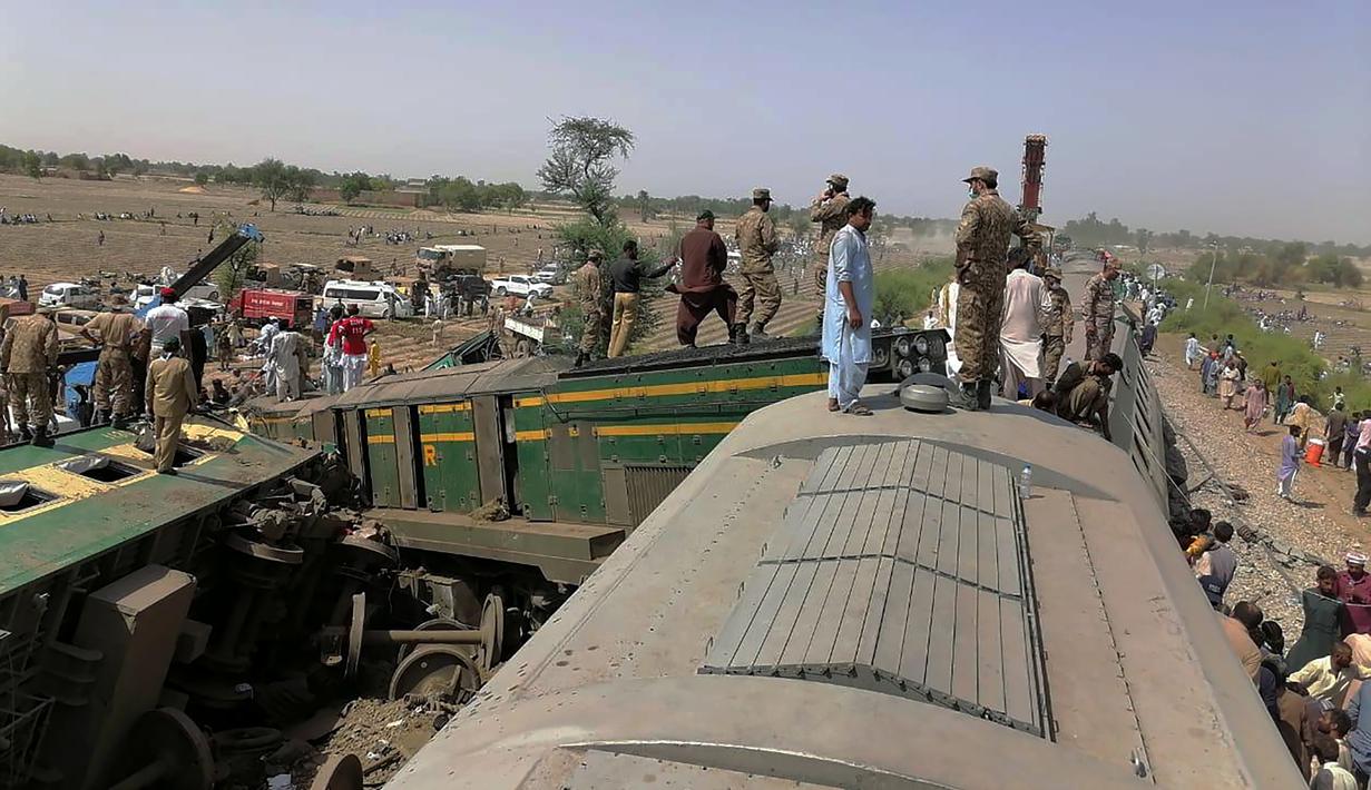 Pasukan dan penyelamat bekerja di lokasi tabrakan kereta api di distrik Ghotki di Pakistan selatan, Senin (7/6/2021). Sedikitnya 30 orang tewas serta puluhan penumpang luka-luka akibat kecelakaan tersebut dan telah dievakuasi ke rumah sakit. (Inter Services Public Relations vis AP)