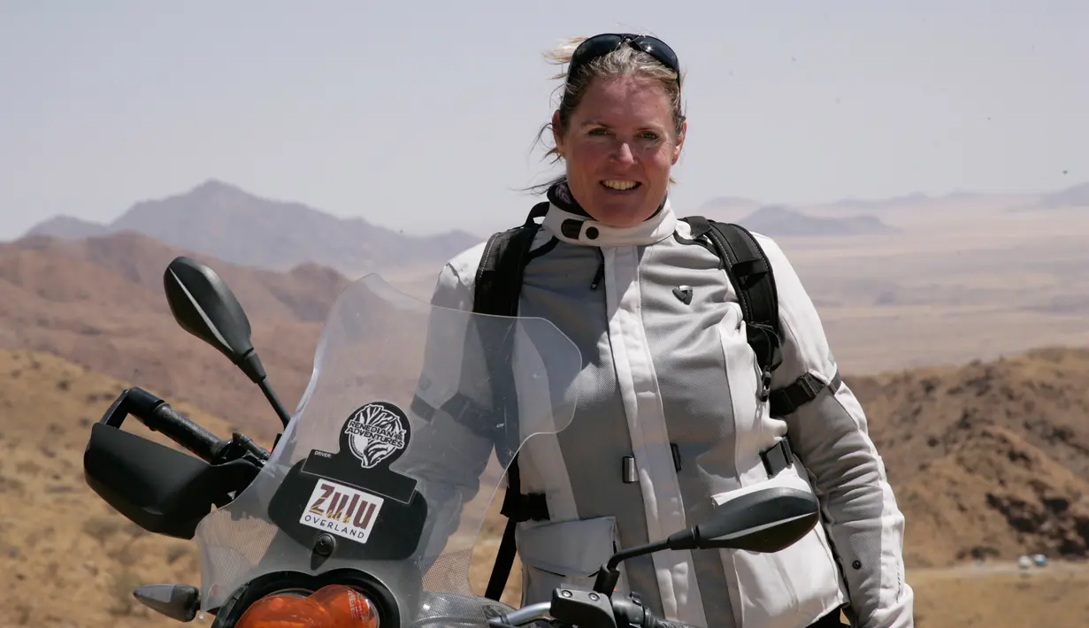 Alisa Clickenger berpose dengan sepeda motornya saat berada di Namibia, Afrika pada Oktober 2014. Sejak tahun 2009, Clickenger sudah melakukan tur lintas negara menggunakan sepeda motornya seorang diri. (Courtesy of Alisa Clickenger via AP)
