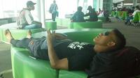 Ahmad Bustomi, salah seorang pemain Arema yang mengantuk dan tidur di Bandara Sultan Aji Muhammad Sulaiman, Sepinggang, Balikpapan, Minggu (10/1/2016) pagi WITA. (Bola.com/Kevin Setiawan)