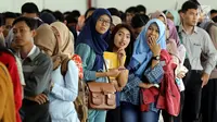 Peserta mengantre untuk pendaftaran ulang ujian CPNS Kementerian Kelautan dan Perikanan (KKP) di Jakarta, Minggu (8/10). Pembukaan lowongan CPNS ini dalam rangka mengisi kekosongan 41 jabatan pada Kantor Pusat dan UPT di KKP. (Liputan6.com/Johan Tallo)