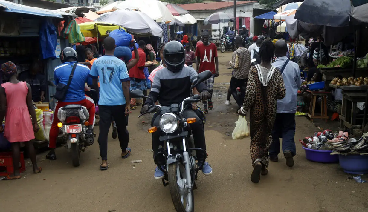 Orang-orang berbelanja di pasar Kaporo di Conakry, Guinea, Senin (13/9/2021). Pasukan elit militer Guinea melakukan kudeta dan menangkap Presiden Alpha Conde pada Minggu, 5 September lalu. (AP Photo/ Sunday Alamba)