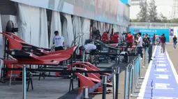 Kru tim peserta lomba balap melakukan persiapan mobil listrik Formula E  di pit Jakarta International E-Prix Circuit (JIEC), Jakarta, Jumat (3/6/2022). Menjelang pertandingan Formula E pada besok hari (4/6/2022) kru tim pembalap melakukan persiapan mobil listrik Formula E. (Liputan6.com/Herman Zakharia)