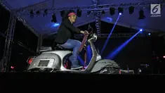 Vokalis band Slank, Kaka mengendarai Vespa di atas panggung konser perayaan HUT ke-34 Slank di JIExpo Kemayoran, Jakarta, Selasa (26/12). Band beraliran rock dan blues tersebut berdiri sejak 26 Desember 1983. (Liputan6.com/Herman Zakharia)