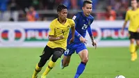 Pemain Timnas Malaysia, Syahmi Safari (kiri), saat melawan Timnas Thailand di leg kedua semifinal Piala AFF 2018 di Stadion Rajamangala, Bangkok (5/12/2018).  (AFP/Lillian Suwanrumpha)