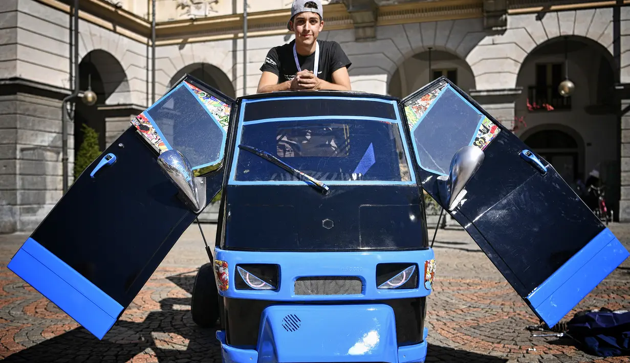 Seorang remaja berpose sambil memerkan Ape milikinya saat pameran memperingati 70 tahun Ape di Aosta, Italia utara (1/7). Dalam acara ini pemilik dan kolektor Piaggio Ape berkumpul untuk merayakan ulang tahun Ape yang ke-70. (AFP Photo/Marco Bertorello)
