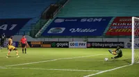 Kiper Persib Bandung, Teja Paku Alam (kanan) berhasil menggagalkan penalti pemain Bhayangkara FC, Ezechiel Ndouassel dalam laga pekan ke-7 BRI Liga 1 2021/2022 di Stadion Moch Soebroto, Magelang, Sabtu (16/10/2021). (Bola.com/Bagaskara Lazuardi)