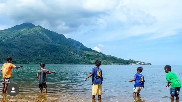 Pemandangam anak-anak tengah berada di pantai dengan latar Gunung Wurlali. (Dok: Instagram @zikriulhaq https://www.instagram.com/zikriulhaq?igsh=MWg4eTl3bXVmenZhMQ==)