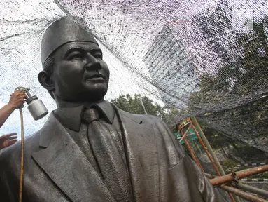Pekerja melakukan proses konservasi pada Patung Mohammad Husni Thamrin di Jakarta, Sabtu (25/11). Konservasi dilakukan untuk melestarikan cagar budaya serta merawat patung agar kondisinya tetap baik. (Liputan6.com/Immanuel Antonius)