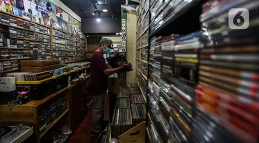 Pecinta musik memilah Piringan Hitam, CD, dan Kaset pita di toko "Wow Record Store", Blok M Squere, Jakarta, Jumat (12/3/2021). Pedagang Piringan Hitam, CD, dan Kaset Pita ini bertahan ditengah Perkembangan era digital dan Pandemi. (Liputan6.com/Johan Tallo)
