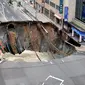 Sebuah lubang raksasa atau yang biasa disebut sinkhole tiba-tiba muncul di persimpangan dekat Stasiun Hakata, Fukuoka, Jepang, Selasa (8/11). Jalanan itu tiba-tiba runtuh hingga menciptakan lubang besar dan menghebohkan warga sekitar. (Kyodo/via REUTERS)