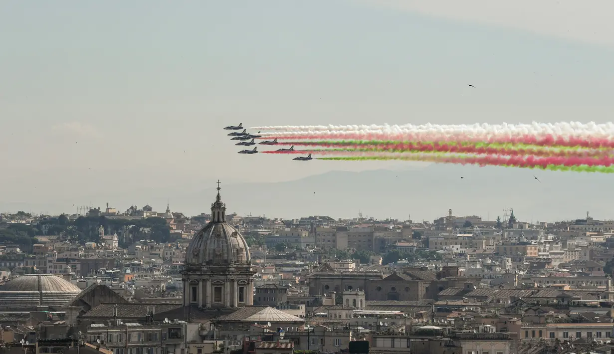 Asap dari unit aerobatik Angkatan Udara Italia Frecce Tricolori yang berwarna bendera negara Italia menghiasi kota Roma, Italia (2/6). (AFP Photo/ Andreas Solaro)