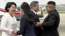 Gambar dari video yang disediakan oleh KBS, Presiden Korea Selatan, Moon Jae-in dan istrinya Kim Jung-sook disambut oleh pemimpin Korea Utara, Kim Jong-un dan sang istri, Ri Sol Ju setibanya di Pyongyang, Selasa (18/8). (Korea Broadcasting System via AP)