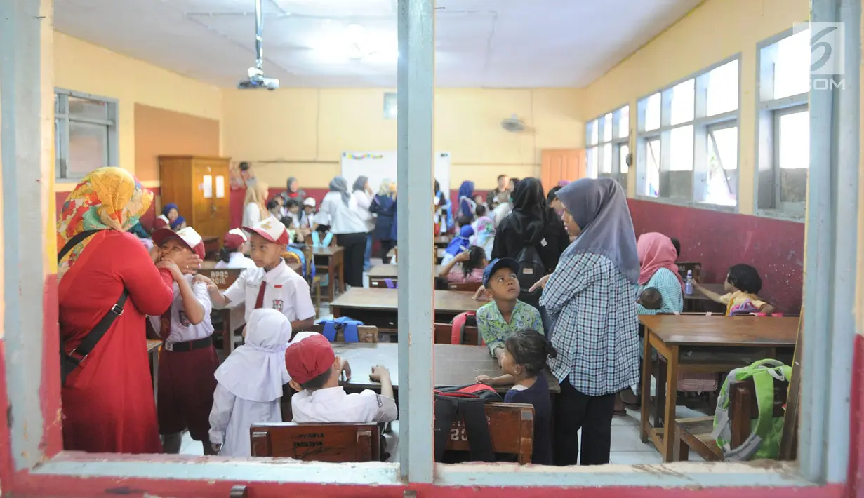 Sejumlah orang tua mendampingi putra-putri mereka di hari pertama sekolah di SDN Cinere 1, Depok, Jawa Barat, Senin (15/7/2019). Seluruh siswa SD, SMP dan SMA, pada hari ini mulai masuk sekolah pada tahun ajaran baru 2019/2020. (merdeka.com/Arie Basuki)