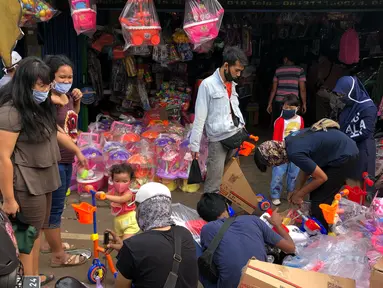 Warga memilih mainan tanpa menjaga jarak di Pasar Gembrong, Jakarta Timur, Minggu (31/5/2020). Meski penerapan masa Pembatasan Sosial Berskala Besar (PSBB) di Jakarta masih berlaku, namun pasar yang khusus menjual pernak-pernik mainan anak ini kembali dipadati warga. (Liputan6.com/Immanuel Antonius)