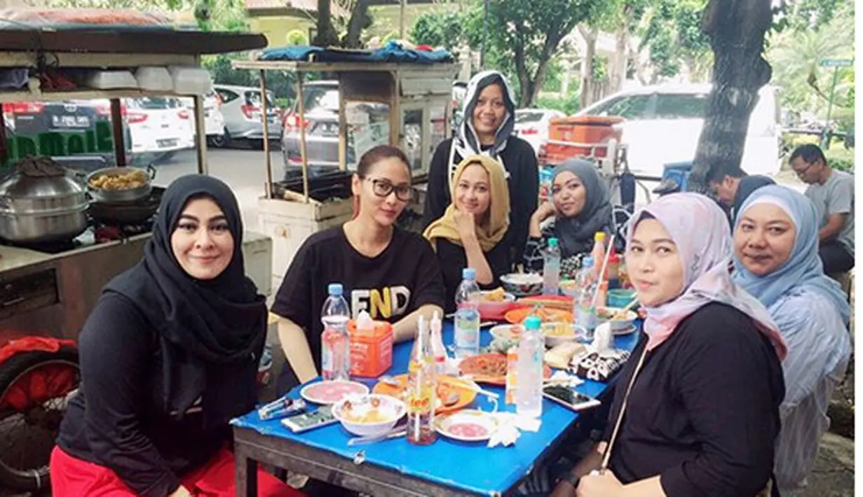 Penyanyi yang juga juri acara dangdut di Indosiar itu santai makan mie ayam. Bukan di hotel bintang lima, tapi ia santai makan di pinggir jalan bersama orang tua murid lainnya. (Instagram/inul.d)
