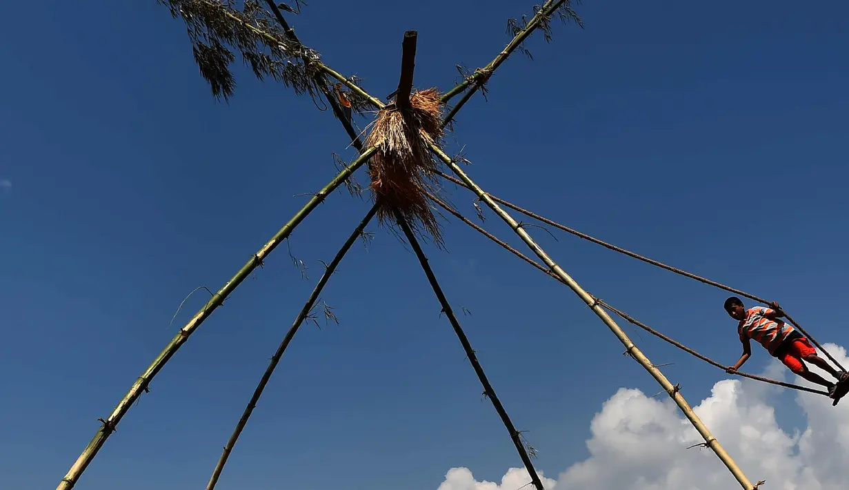  Seorang anak bermain di ayunan khas negara Nepal di Lalitpur pinggiran kota Kathmandu, Nepal (26/9). Ayunan ini dikenal sebagai 'Dashain Ping' dan dimainkan pada hari keenam festival Hindu Dashain. (AFP Photo/Prakash Mathema)