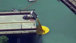 Ribuan bebek karet dilemparkan ke sungai Chicago, pusat kota Chicago, Kamis (9/8). Lebih dari 50.000 bebek karet dilombakan di Sungai Chicago sebagai bagian dari acara amal Windy City Rubber Ducky Derby. (WBBM-TV via AP)