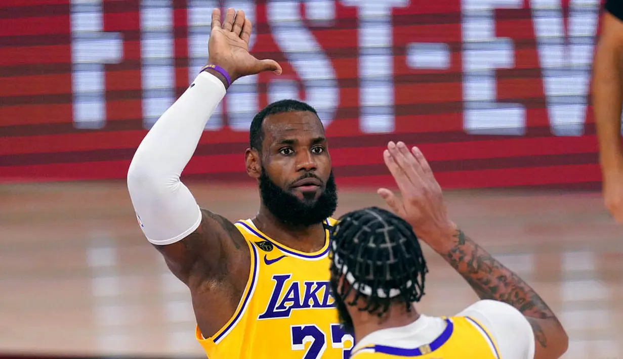 Pebasket Los Angeles Lakers, LeBron James dan Anthony Davis, melakukan selebrasi saat melawan Miami Heat pada gim pertama final NBA di Lake Buena Vista, Kamis (1/10/2020). Lakers menang dengan skor 116-98. (AP Photo/Mark J. Terrill)