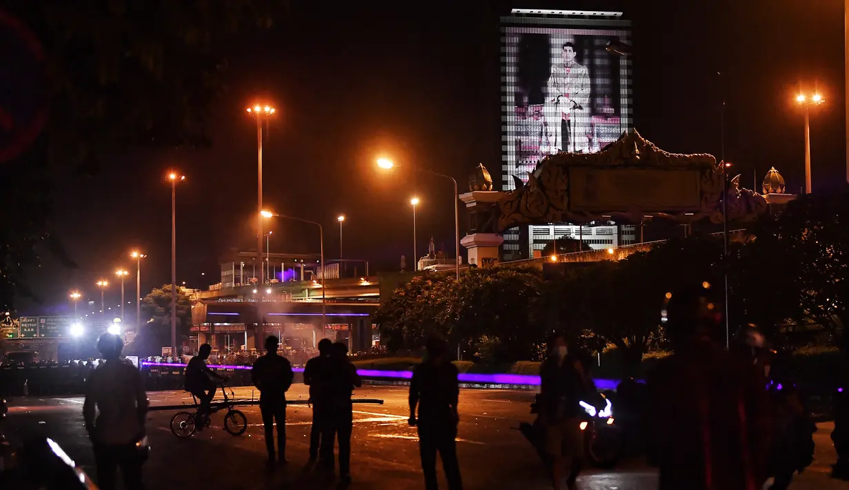 Pengunjuk rasa anti-pemerintah berhadapan dengan polisi saat demonstrasi di Bangkok, Thailand, Minggu (6/9/2021). Mereka memprotes ketidaksetujuan terhadap cara pemerintah Thailand menangani pandemi dan pemberian vaksin Covid-19. (AFP/Lillian Suwanrumpha)