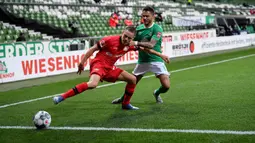 Pemain Werder Bremen Leonardo Bittencourt (kanan) berebut bola dengan pemain Bayer Leverkusen Florian Wirtz dalam pertandingan Bundesliga di Bremen, Jerman, Senin (18/5/2020). Bayer Leverkusen menang 4-1. (Stuart FRANKLIN/POOL/AFP)