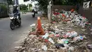 Pengendara melintasi tumpukan sampah rumah tangga di Jalan Raya Tanah Baru kawasan Depok, Jawa Barat, Rabu (15/5/2019). Kurangnya tempat penampungan membuat warga terpaksa membuang sampah di lokasi tersebut, meskipun menimbulkan bau tidak sedap serta mengotori jalan. (Liputan6.com/Immanuel Antonius)