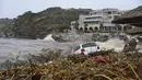 Pemandangan mobil yang terbengkalai di dekat laut setelah hujan deras di desa Agia Pelagia, di pulau Kreta, Yunani, Sabtu (15/10/2022). Dilaporkan setidaknya satu orang tewas dan lainnya hilang setelah banjir bandang yang parah. (AP Photo/Harry Nakos)