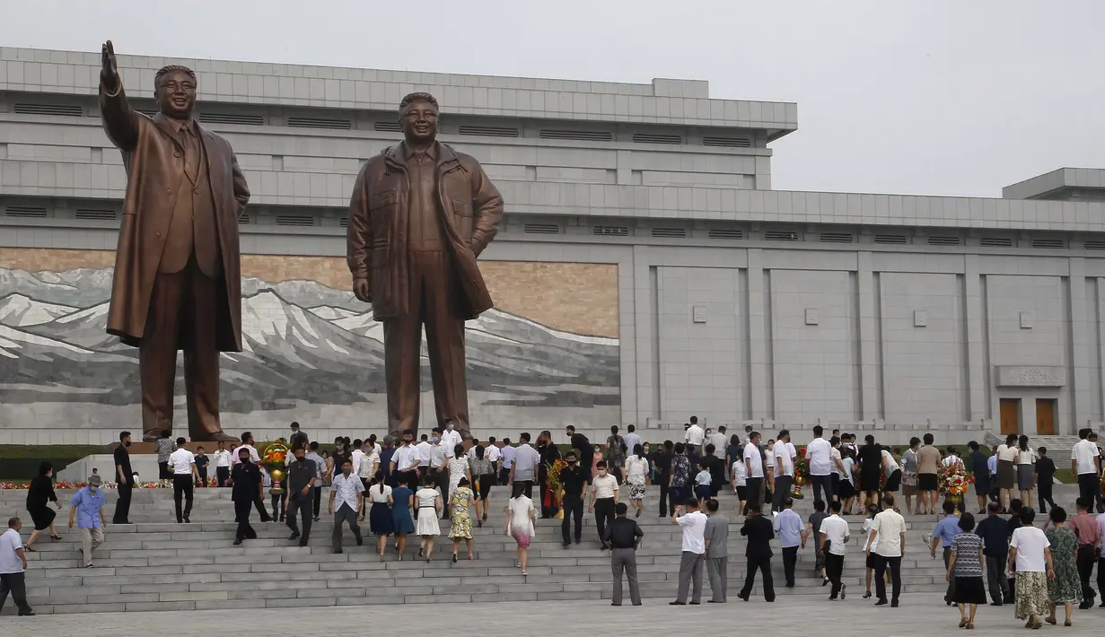 Sejumlah warga mengunjungi Mansu Hill untuk memberi penghormatan terhadap patung-patung perunggu dari Kim Il-sung dan Kim Jong-il pada peringatan 26 tahun kematian Kim Il-sung di Pyongyang, Korea Utara, Rabu (8/7/2020). (AP Photo/Jon Chol Jin)
