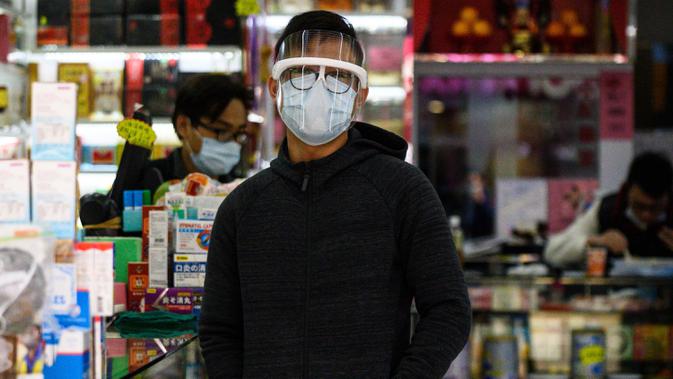Seorang karyawan farmasi mengenakan masker untuk melindungi diri dari wabah virus corona di Hong Kong pada 1 Februari 2020. Awal tahun 2020 ini, masyarakat dunia dikejutkan dengan hadirnya virus corona COVID-19 yang mematikan asal Wuhan, China. (Philip FONG/AFP)
