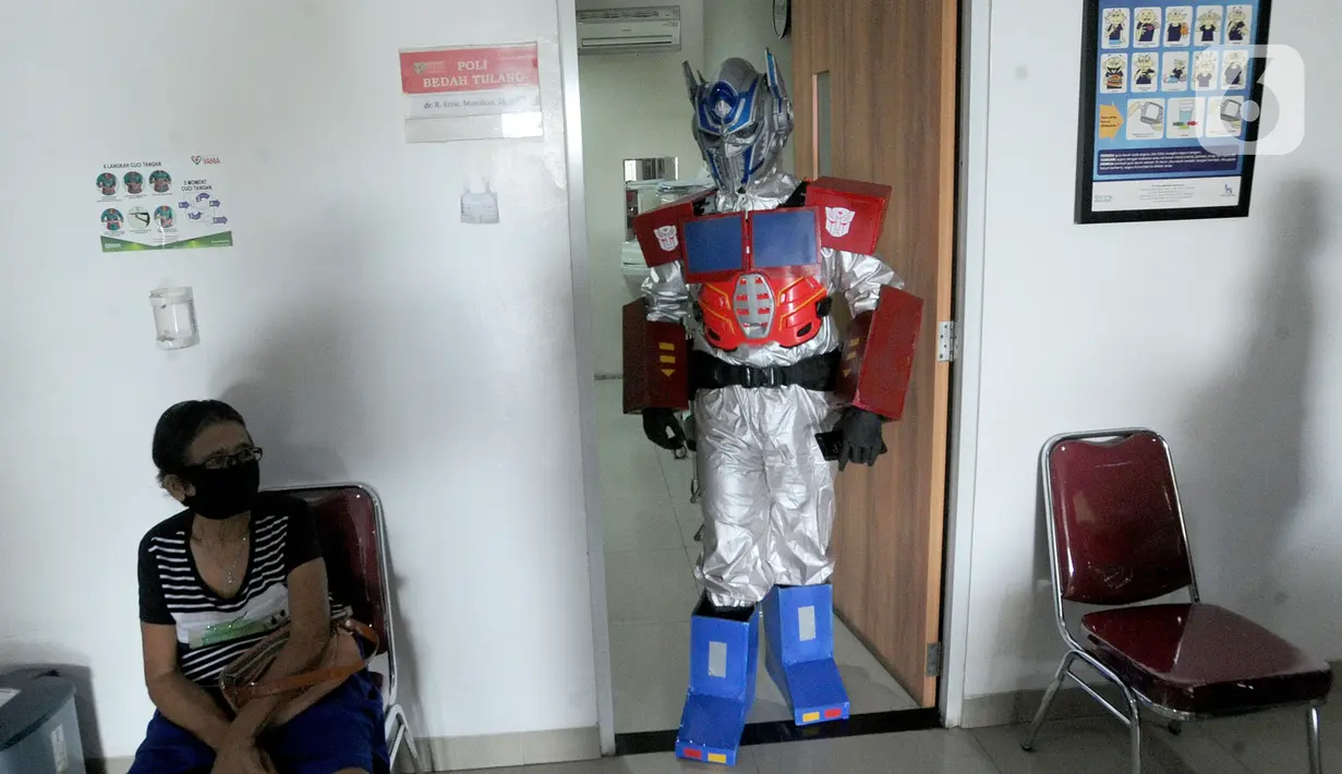 Dokter Rollando Erric Manibuy SpOT mengenakan alat pelindung diri (APD) ala transformer saat berada di RS Vania, Bogor, Jawa Barat, Jumat (22/5/2020). Penggunaan APD unik sejak merebaknya COVID-19 tersebut agar pasien tetap optimis meski sedang dalam pandemi. (merdeka.com/Arie Basuki)