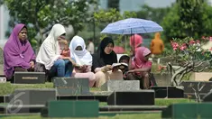Sejumlah warga melakukan ziarah di salah satu makam di Tempat Pemakaman Umum (TPU) Karet Bivak, Jakarta, Rabu (6/7). Setelah melakukan salat Idul Fitri, sebagian warga melakukan ziarah ke makam kerabat mereka. (Liputan6.com/Yoppy Renato)