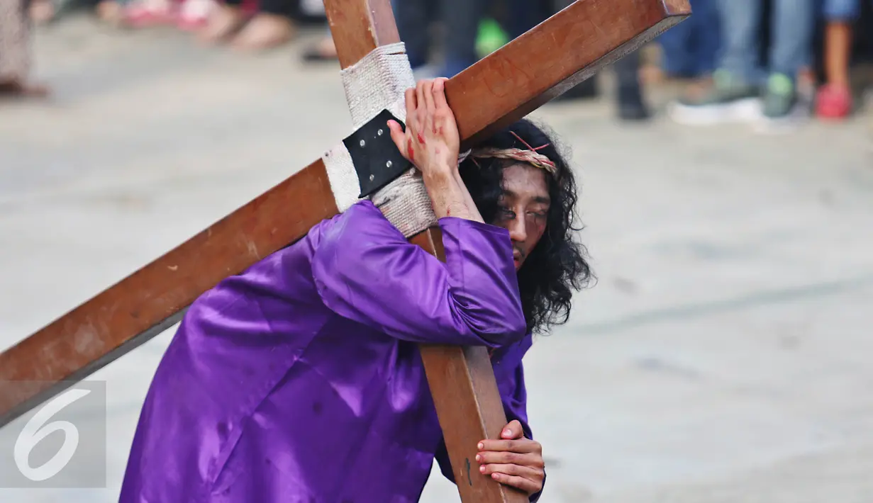 Adegan yang menceritakan Yesus sedang mambawa salib dalam peragaan drama teatrikal Jalan Salib (Tablo) saat perayaan Paskah di Gereja St Matius Penginjil Bintaro, Jumat (14/4). (Liputan6.com/Angga Yuniar)