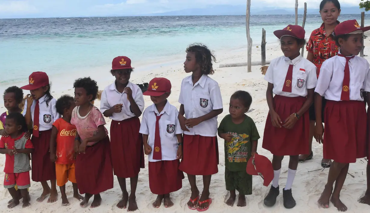Anak-anak suku Byak Betew memakai seragam sekolah saat menyambut pengunjung di pulau Saukabu, satu dari 1.500 pulau di Raja Ampat 20 Agustus 2017. (AFP Photo/Goh Chai Hin)