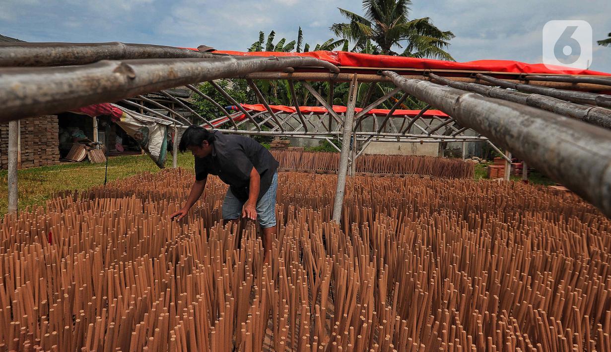 Seorang pekerja menjemur hio dupa di sentra industri kecil pembuatan hio di Tangerang, Banten, Senin (9/1/2023). Jelang perayaan Imlek, pesanan hio dupa mengalami peningkatan untuk kebutuhan sembahyang. (Liputan6.com/Angga Yuniar)