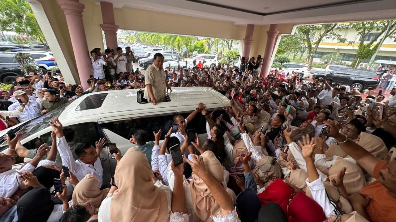 Prabowo menyapa para pendukungnya saat keluar dari VIP BIM dan menuju mobil ditumpanginya.<br>