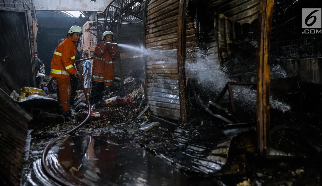 Petugas pemadam kebakaran melakukan pendinginan di lokasi Pasar Induk Kramat Jati Blok C1, Jakarta Timur, yang terbakar, Senin (12/6). Tidak ada korban jiwa atas insiden yang diduga akibat korsleting listrik tersebut. (Liputan6.com/Faizal Fanani)