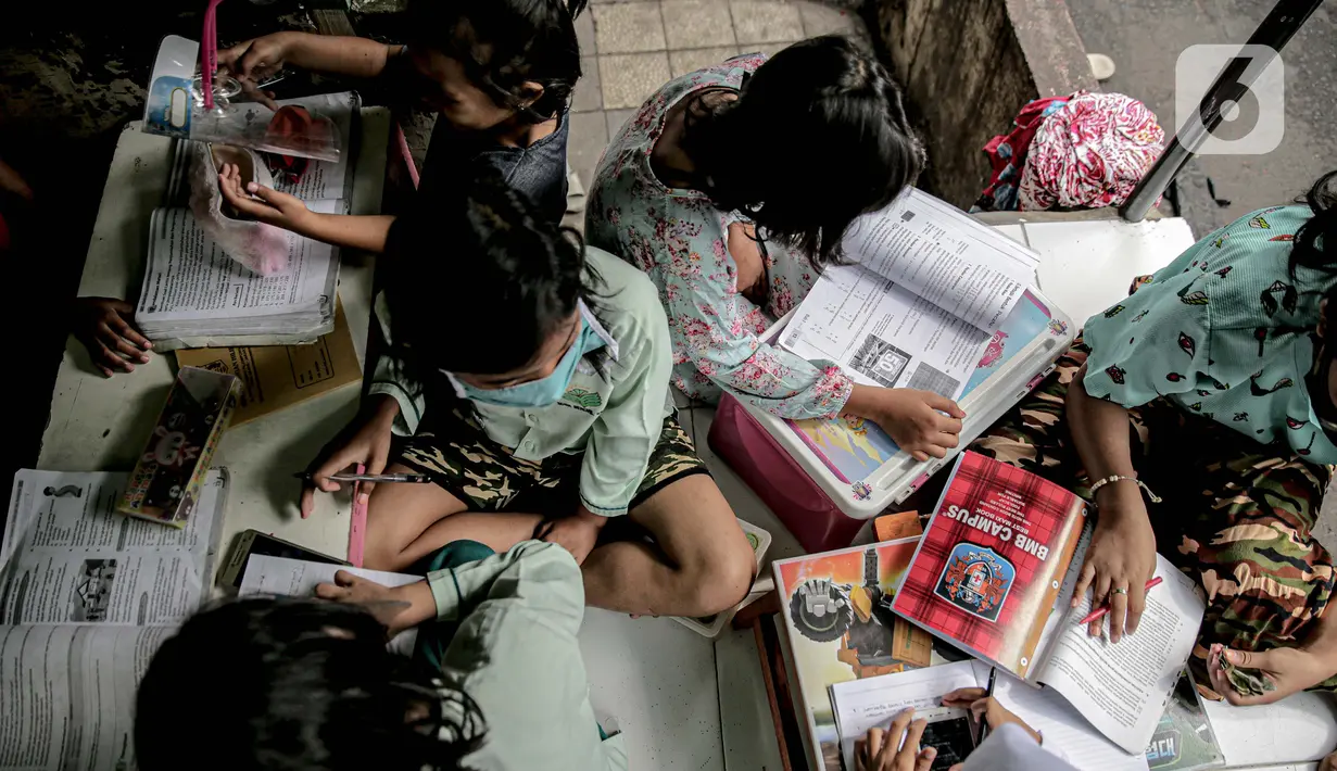 Sejumlah murid SD mengikuti kegiatan pembelajaran jarak jauh di sebuah pos keamanan RT 003 RW 006 Bendungan Hilir, Tanah Abang, Jakarta, Jumat (14/8/2020). Selain itu, mereka juga mengerjakan tugas sekolah yang diberikan oleh guru melalui aplikasi pesan singkat. (Liputan6.com/Faizal Fanani)
