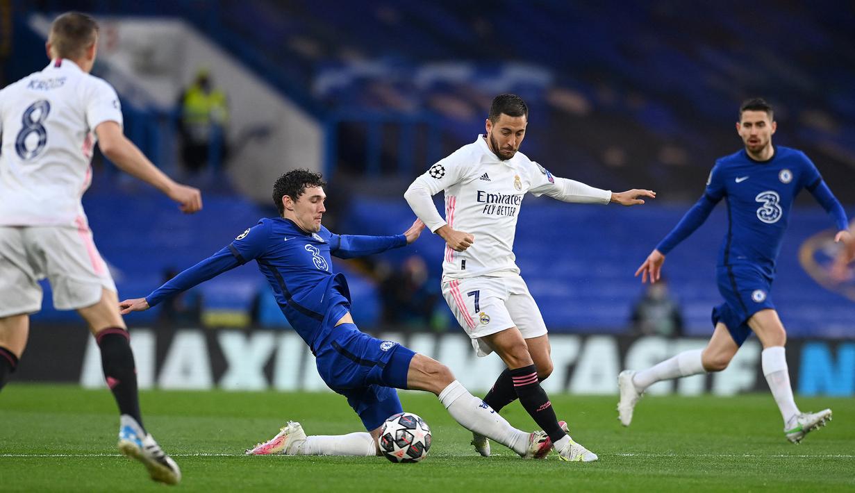 Striker Real Madrid, Eden Hazard (kanan) berebut bola dengan bek Chelsea, Andreas Christensen pada laga leg kedua semifinal 2020/2021 di Stamford Bridge, London (5/5/2021). Eden Hazard mampu meraih trofi Liga Champions bersama Real Madrid pada musim 2021/2022. Ia hanya tampil dalam 3 laga di Liga Champions musim 2021/2022 dan tak dimainkan pada laga final saat menang 1-0 atas Liverpool. (AFP/Glyn Kirk)